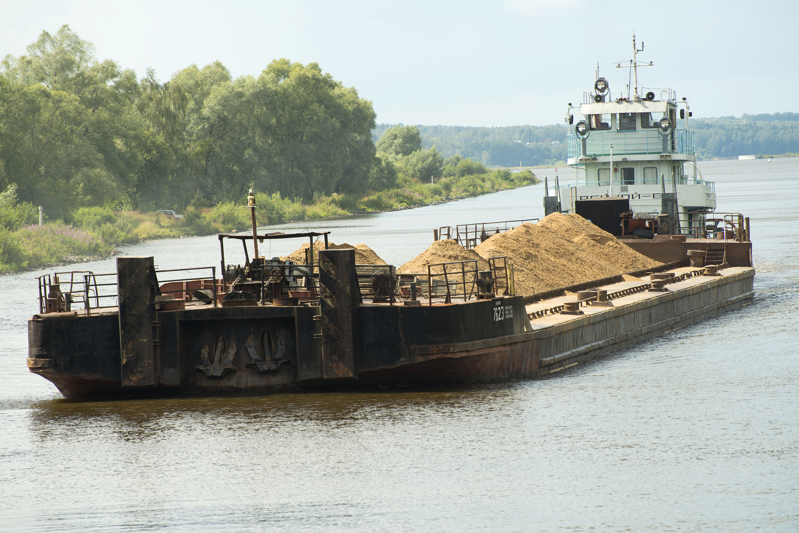 Barge with load on a river using BargeOps Barge Management System (BMS)